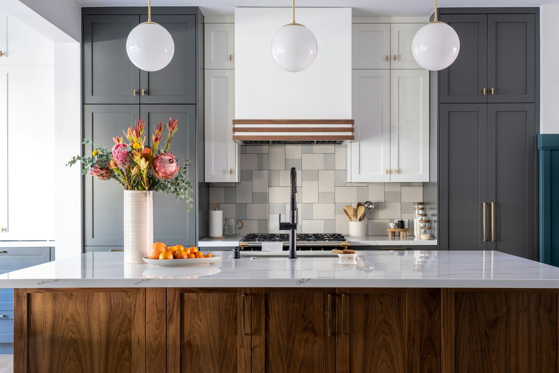 Modern kitchen with gray island, white cabinets, and pendant lights in Youngtown, AZ