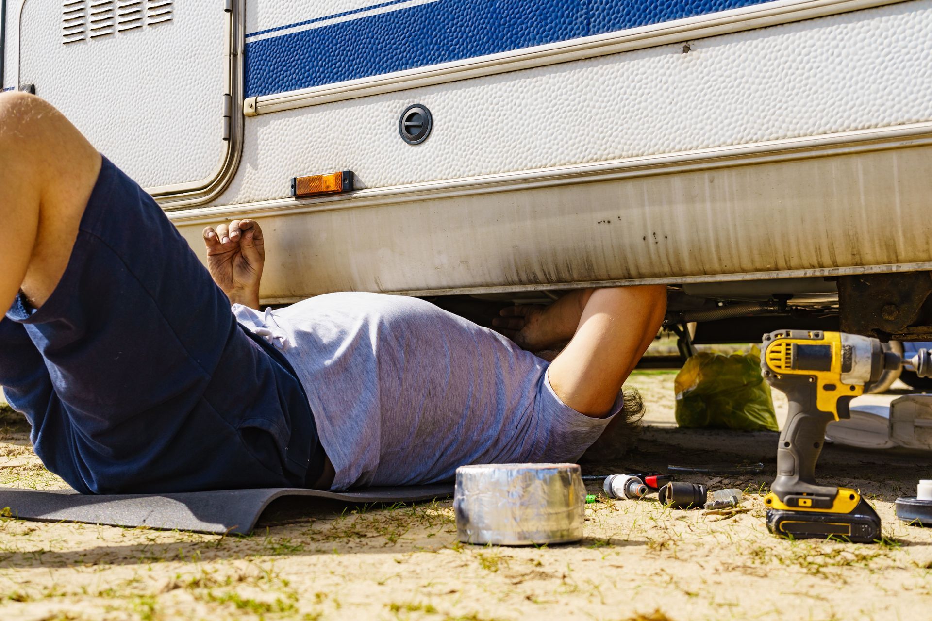 A person is cleaning the floor of a car with a vacuum cleaner.