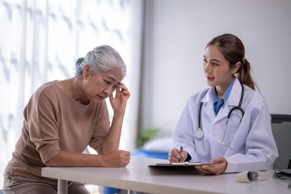 Doctor consulting with a worried patient at a clinic desk