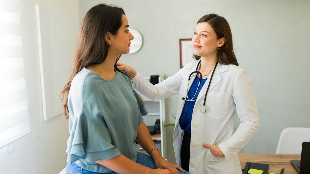 Doctor with stethoscope examining patient in office, personalized care and in-person medical visit