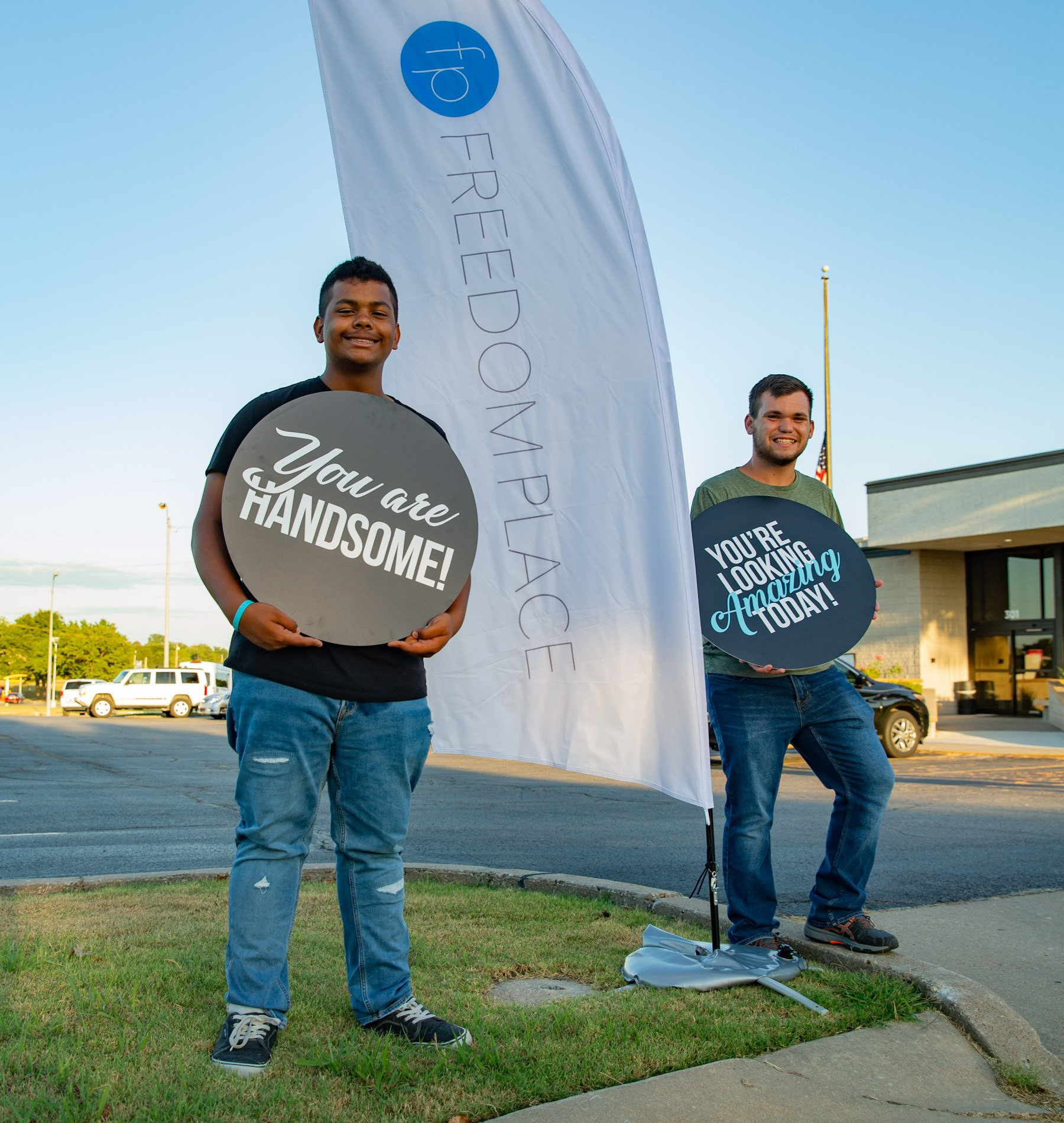 Two men holding signs that say you are handsome