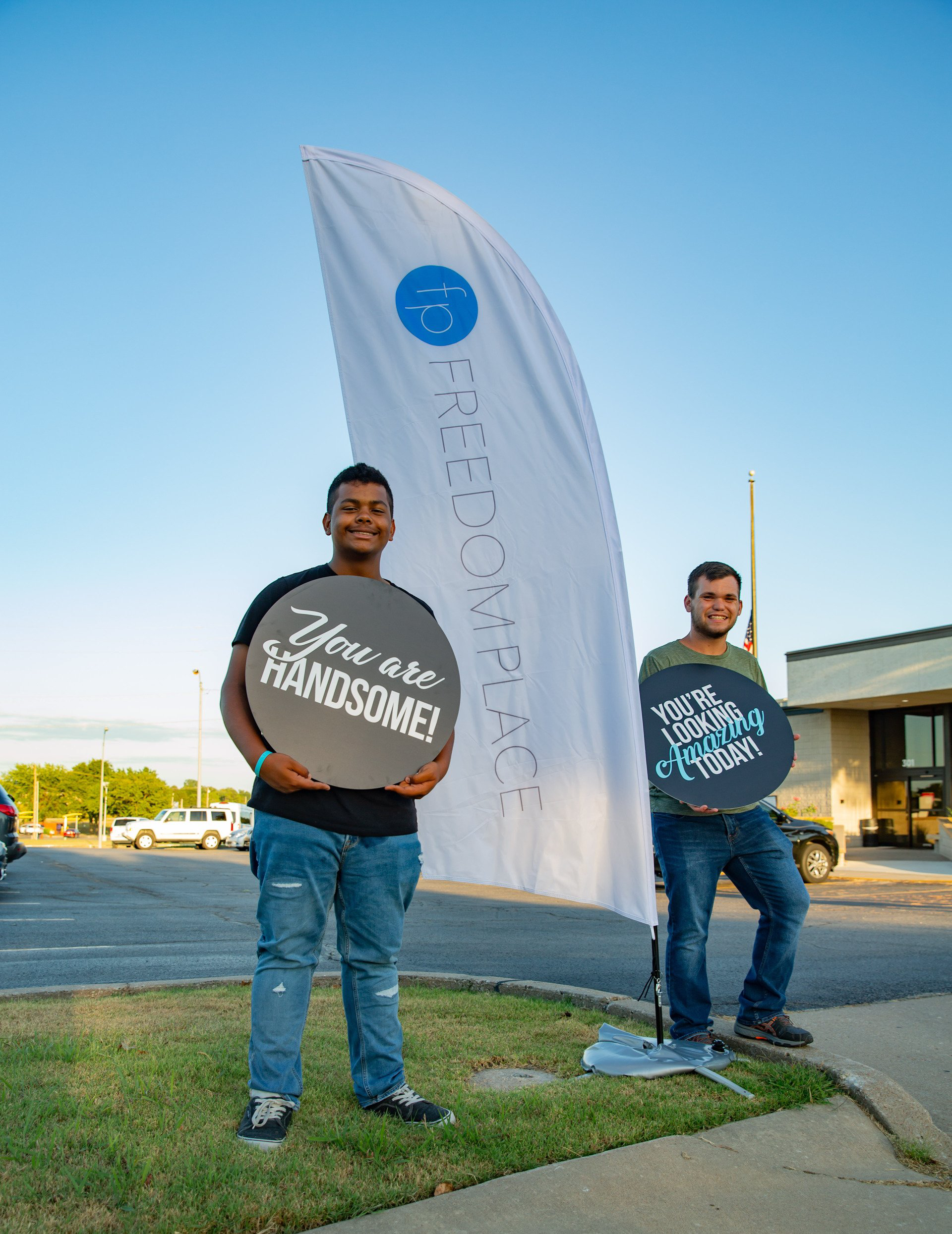 Two men holding signs that say you are handsome