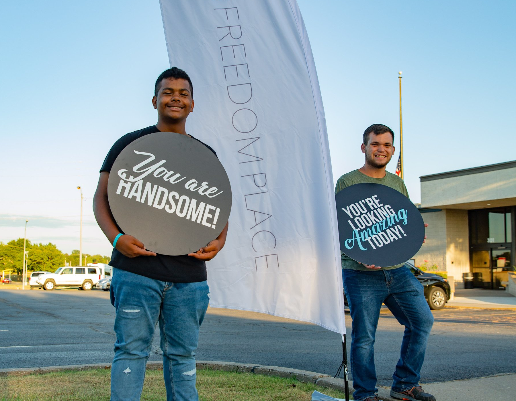 Two men are holding signs that say you are handsome