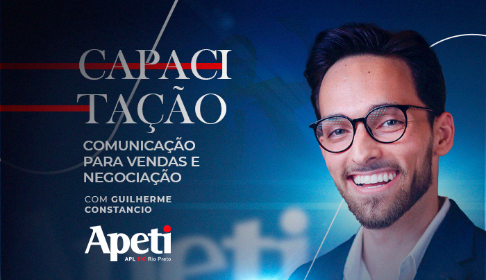 Um homem usando óculos está sorrindo em um fundo azul