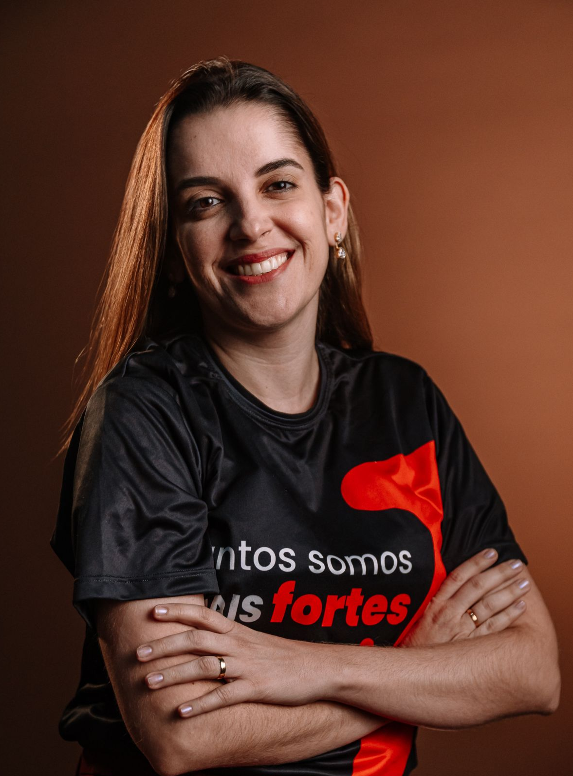 Uma mulher com uma camisa colorida está sorrindo para a câmera.