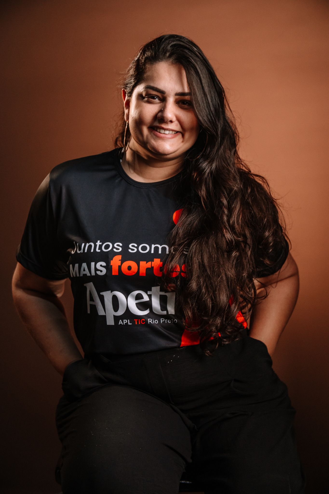 Uma mulher está parada em frente a uma grande letra a.