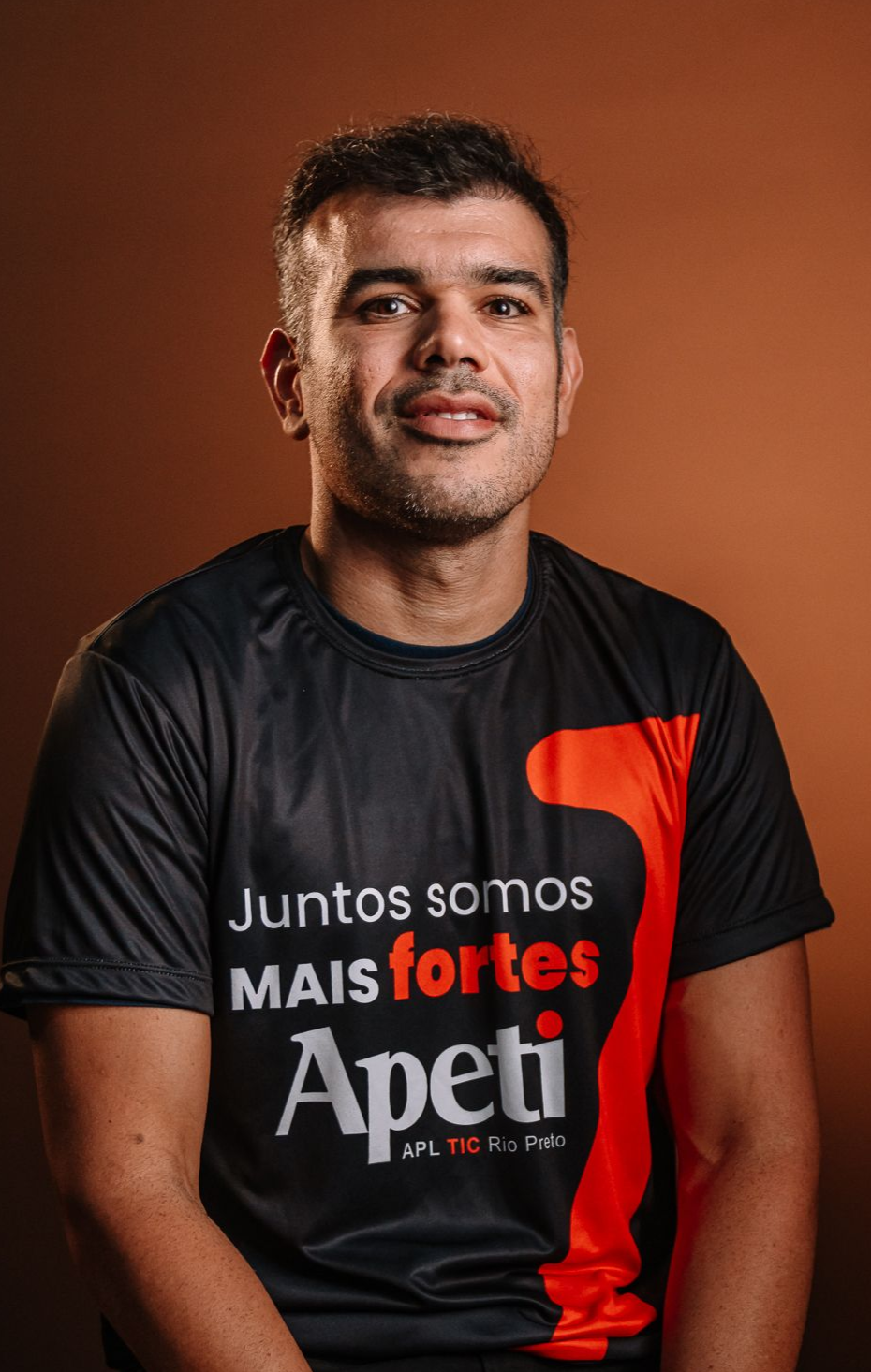 Um homem com os braços cruzados vestindo uma camisa xadrez
