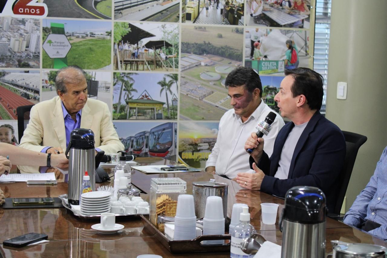 Um grupo de homens está sentado ao redor de uma mesa tendo uma reunião.