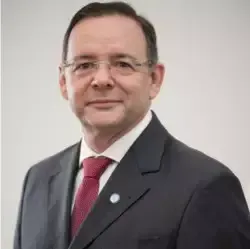 Um homem de terno e gravata está sorrindo para a câmera.