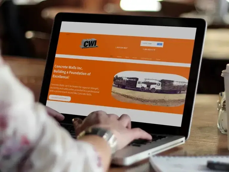 Person using a laptop showing an orange website with a bus photo