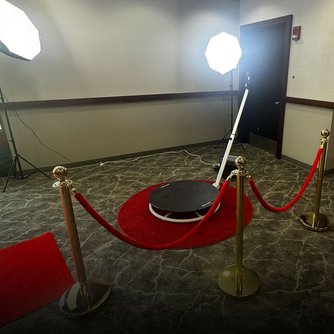 Red carpet stanchions around a small circular platform with two bright lights in a hallway