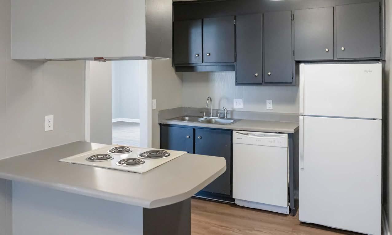 Compact kitchen with white appliances, dark cabinets, and a gray island countertop
