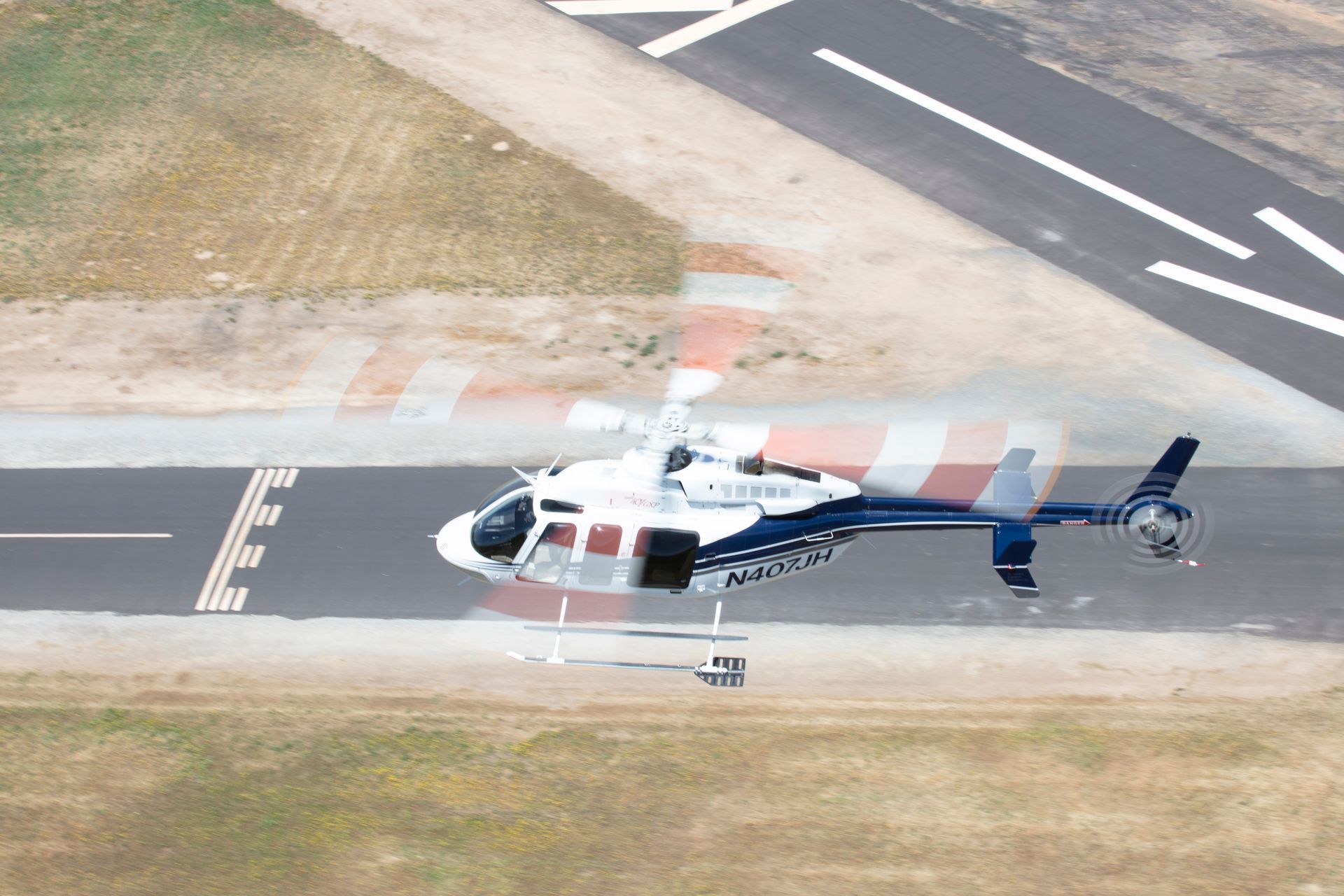 An aerial view of a helicopter taking off from an airport runway