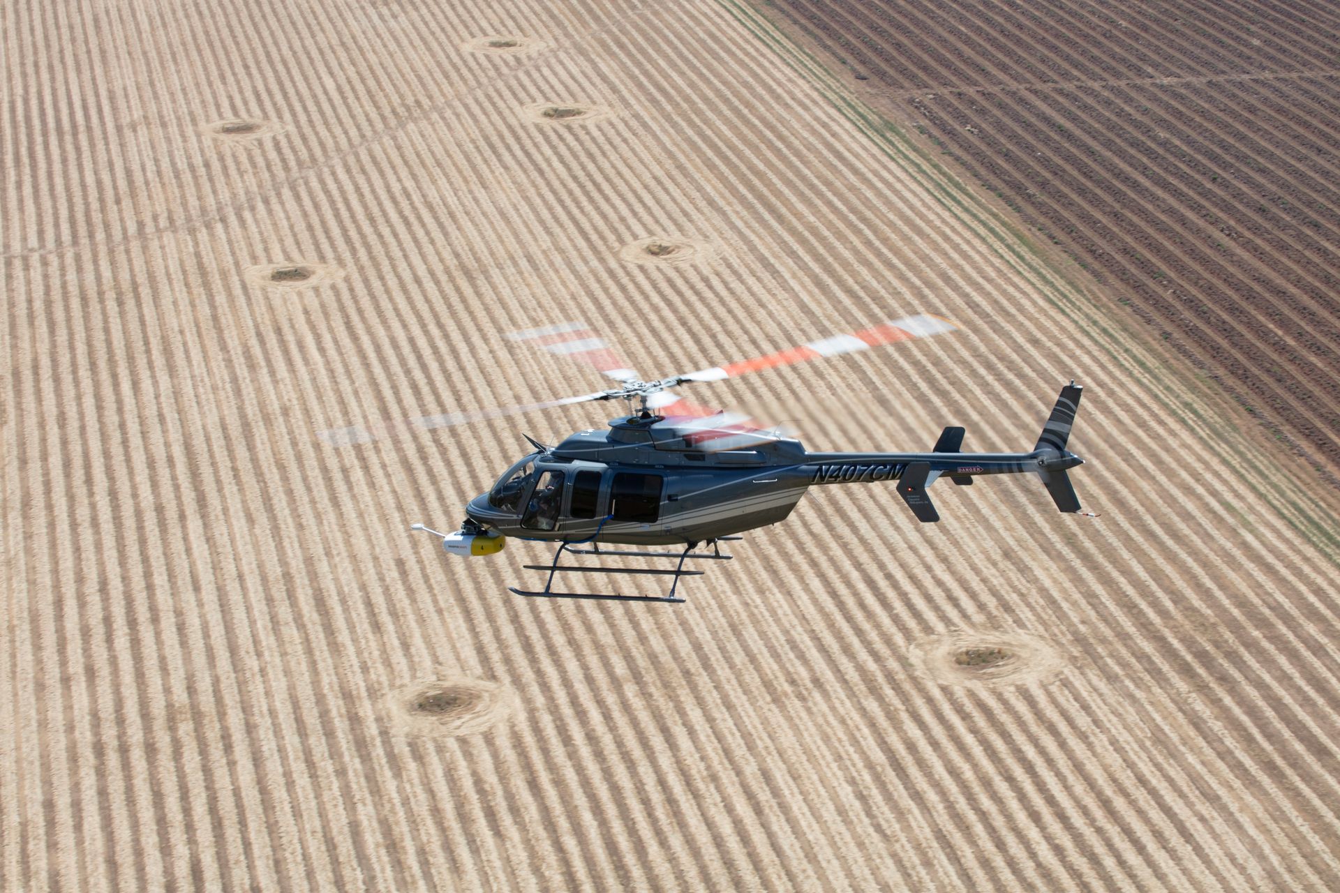 A helicopter is flying over a field.