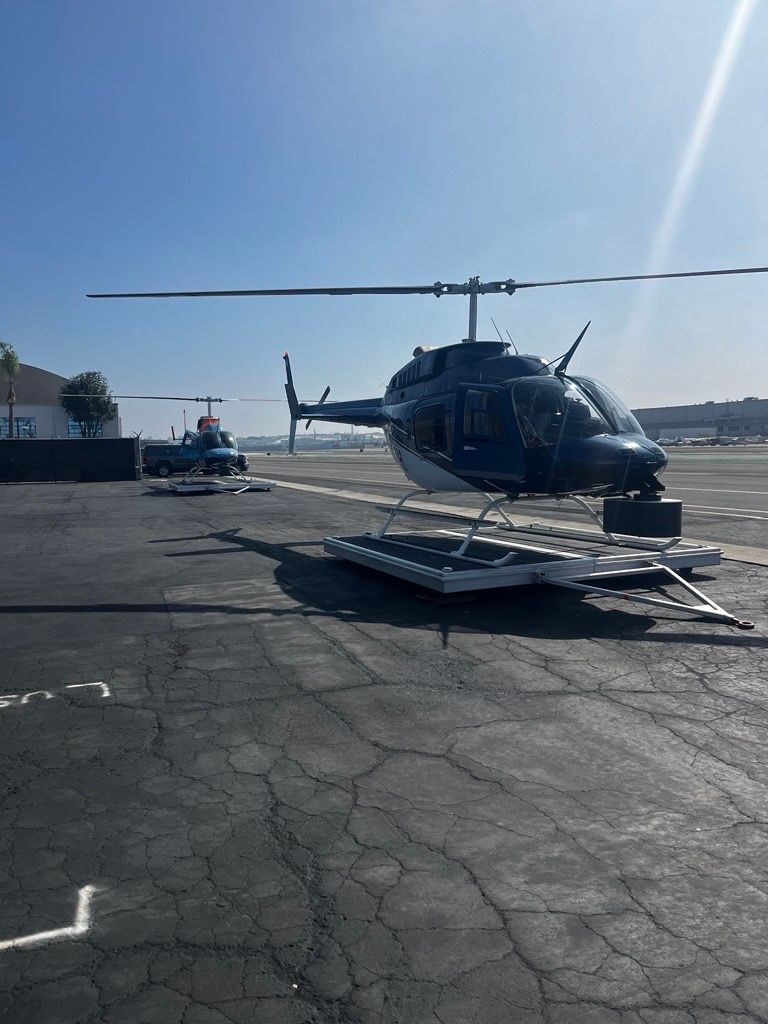 A helicopter is parked on the tarmac at an airport.