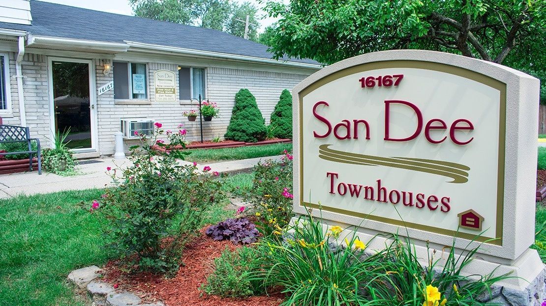 San Dee Townhouses sign in front of a landscaped apartment building