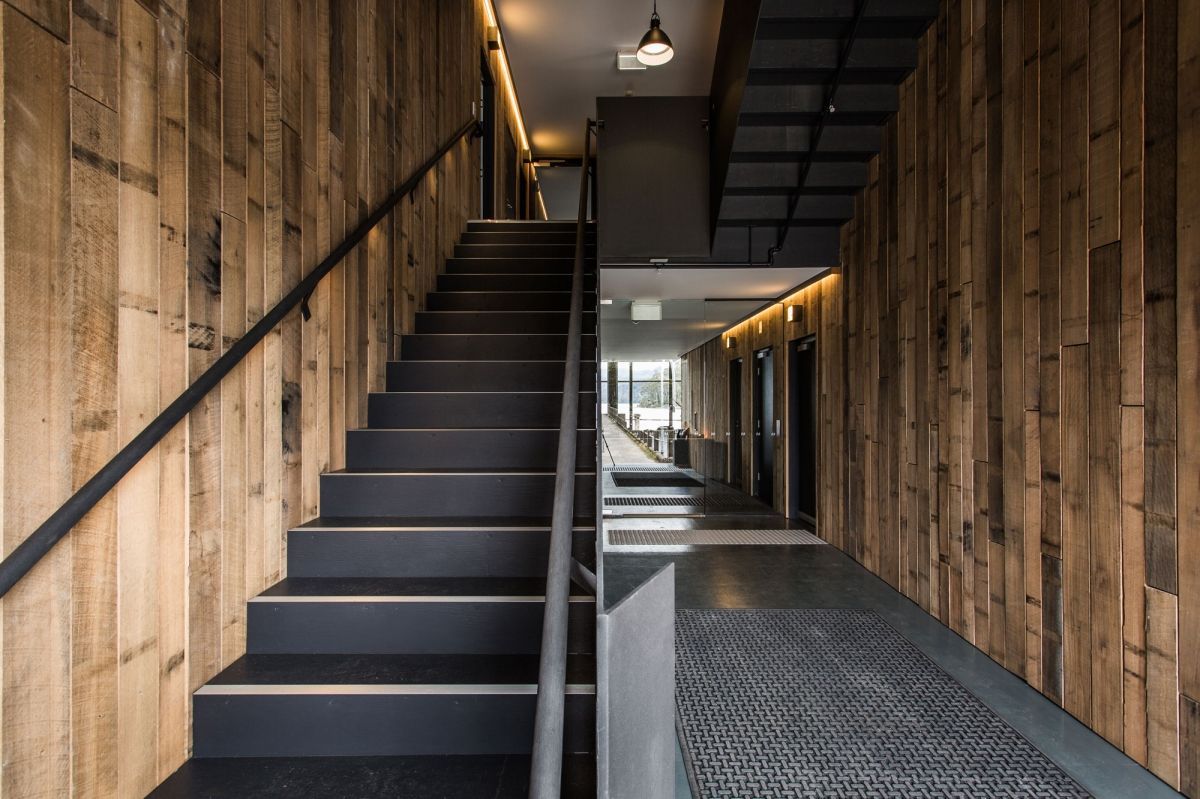 Modern staircase with wood panelling and black metal railings.