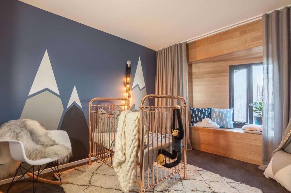 Modern bedroom with mountain mural, wood bed, a chair, and warm lighting