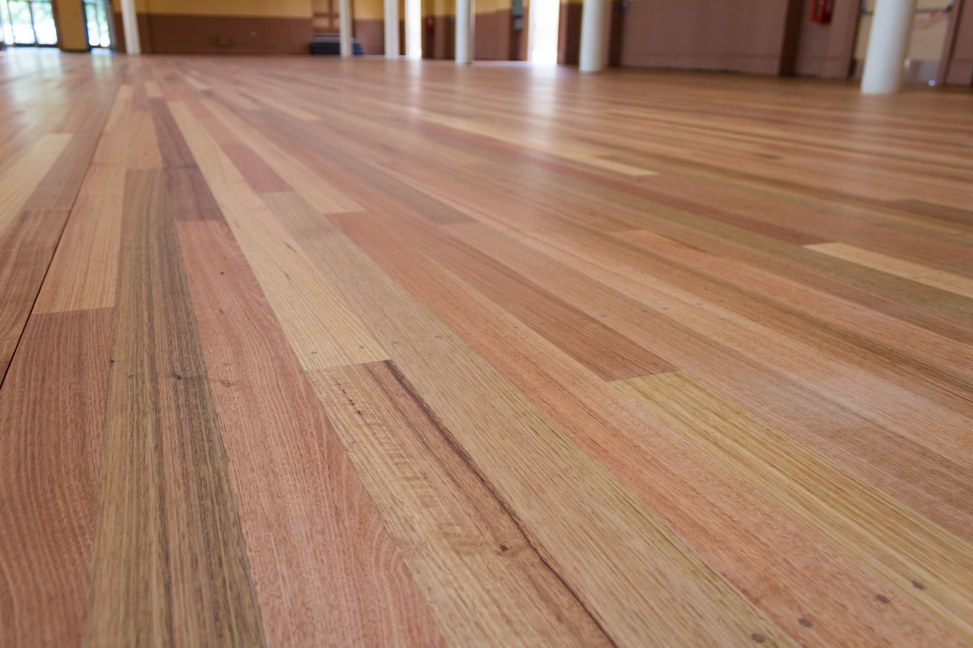 Wooden floorboards in a bright indoor room, viewed from a low angle.