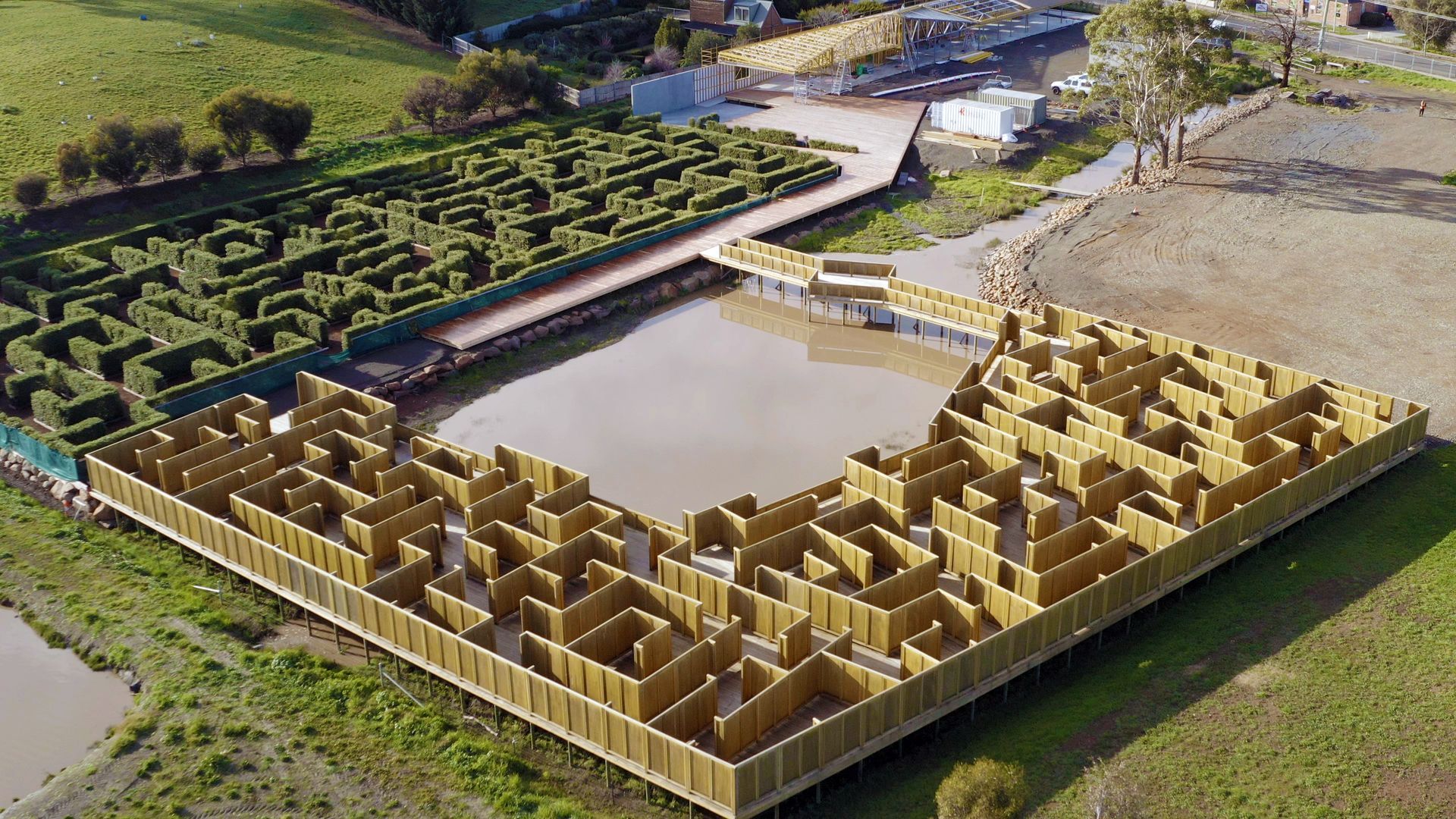 Aerial view of a large hedge maze with a square central courtyard in a rural landscape