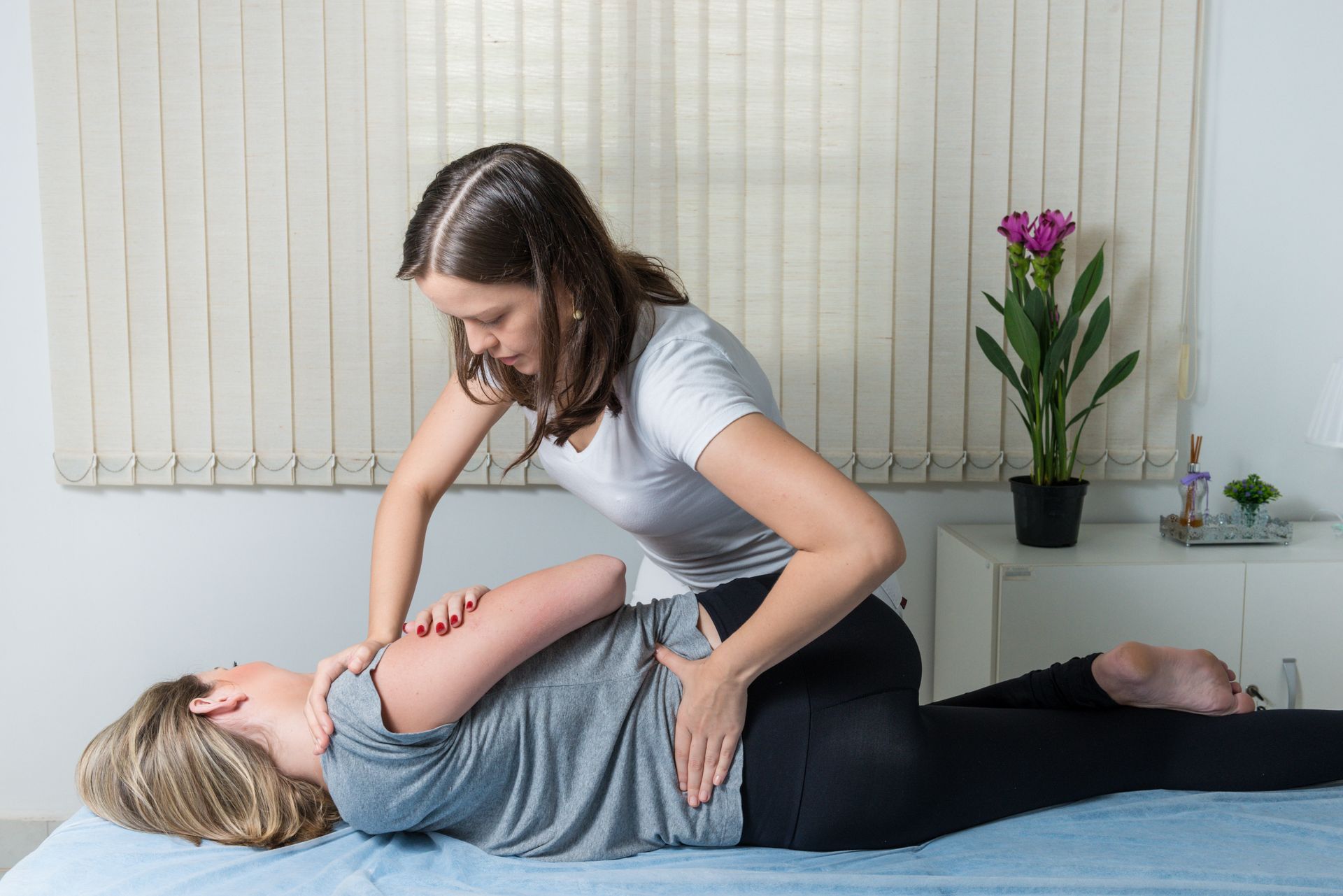 Massage therapist working on a client's back in a spa treatment room