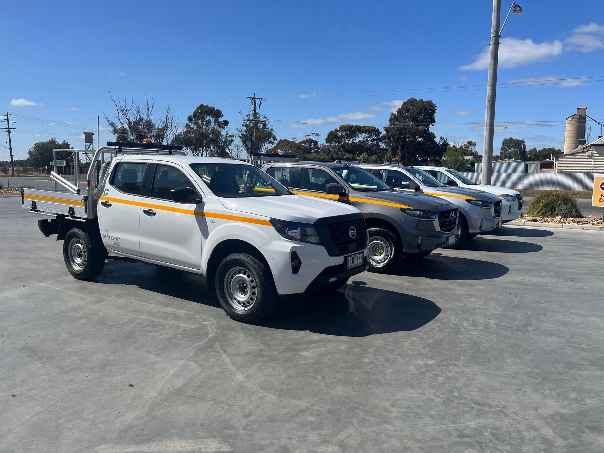 a row of white trucks are parked in a parking lot .