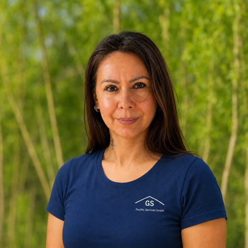 Person in einem dunkelblauen T-Shirt mit GS-Logo auf der Brust vor hellgrauem Hintergrund
