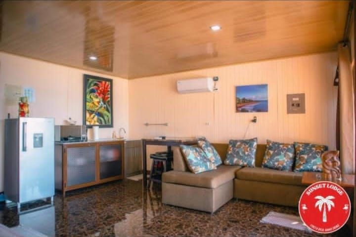Living room interior with a sofa, kitchen area, and a refrigerator.