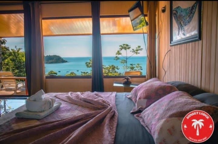 Bedroom with bed, ocean view, and decorative towels.