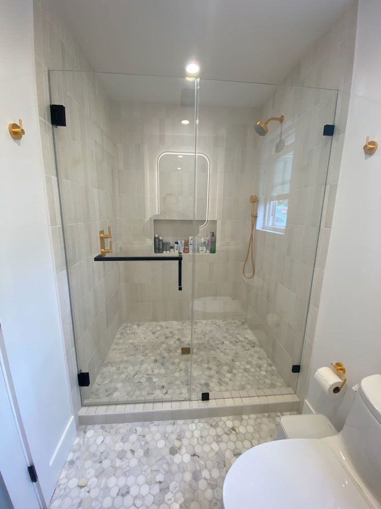 Modern white bathroom with glass walk-in shower and hexagon tile floor