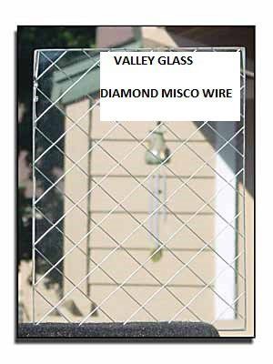 Storefront window with white security mesh and signs reading “Valley Glass” and “Diamond Misco Wire”