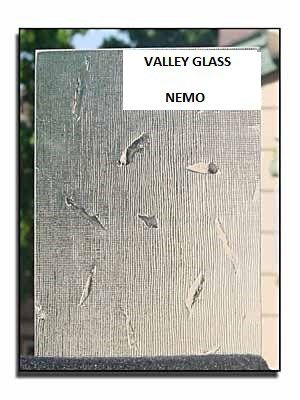 Gray glass sample labeled “Valley Glass” and “Nemo” with fish-like marks on a display board