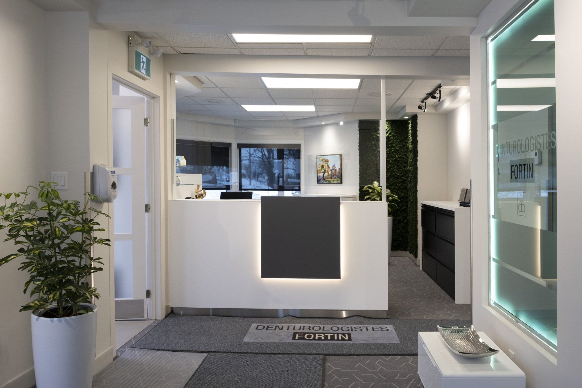Espace d'accueil moderne avec un bureau blanc et des touches de gris.