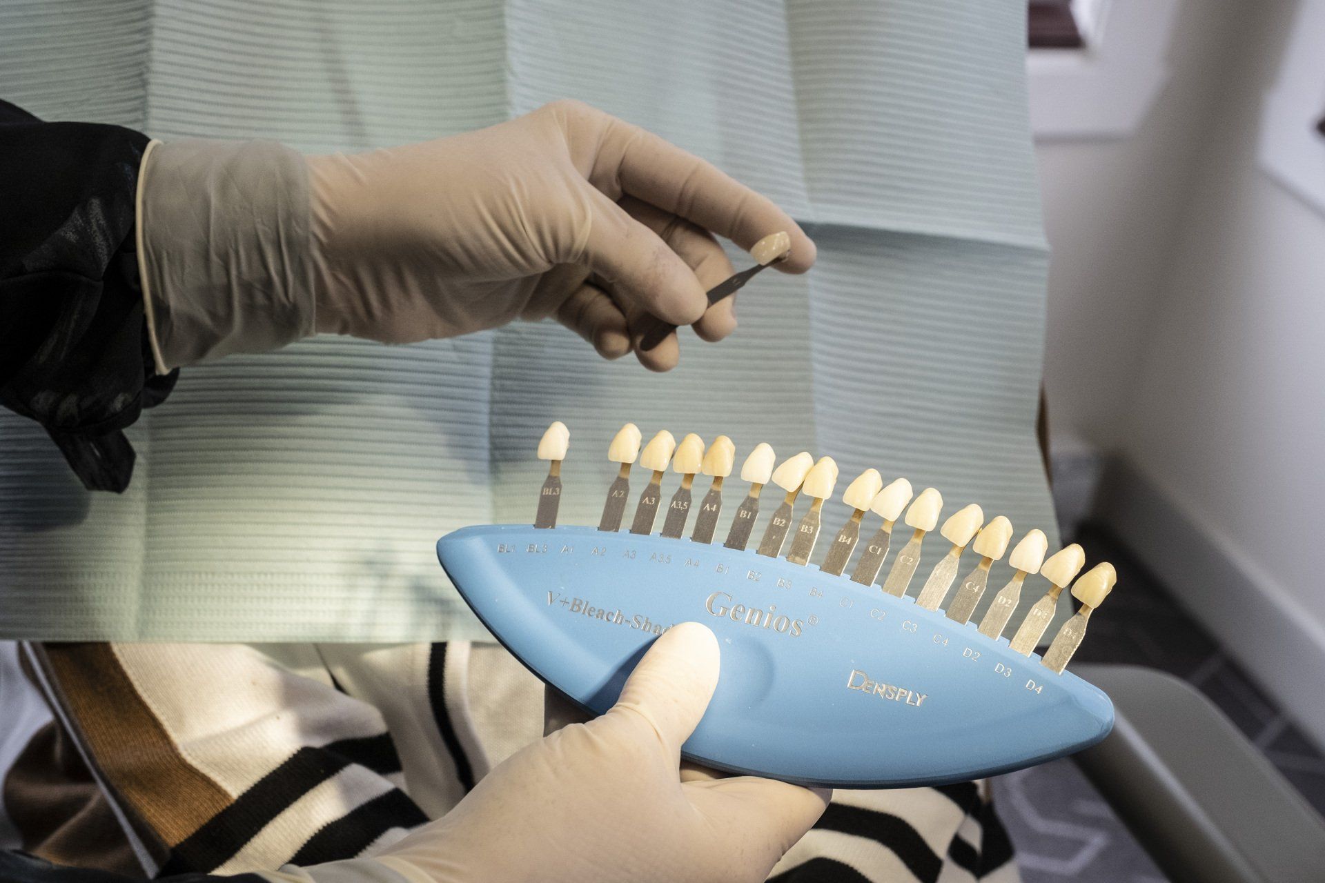 Un dentiste présente un nuancier pour faire correspondre la couleur des dents à celle des dents du patient dans un cabinet dentaire.