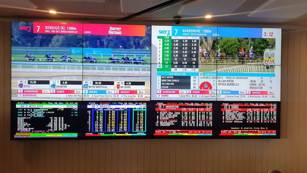 A Wall With a Bunch of Monitors Showing Horse Racing — Inspired Audio Visual in Coffs Harbour, NSW