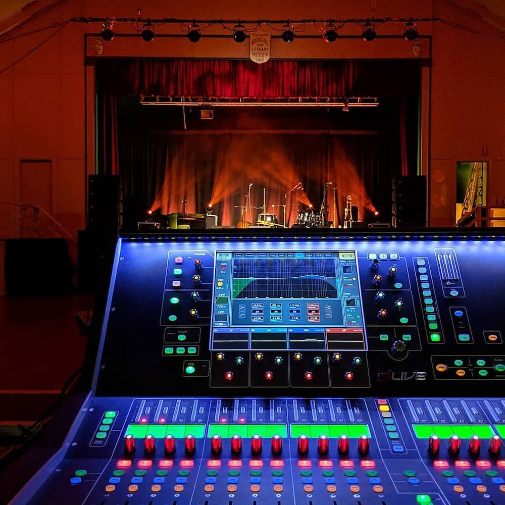 A Mixer in Front of a Stage With a Band on It — Inspired Audio Visual in Coffs Harbour, NSW