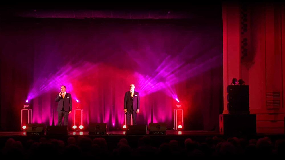 Two Men Singing on a Stage With Purple Lights Behind Them — Inspired Audio Visual in Coffs Harbour, NSW