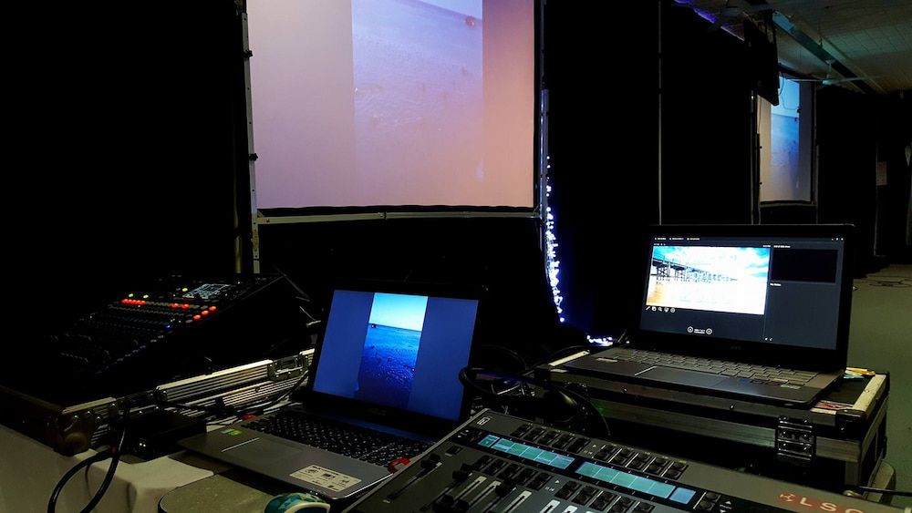 Two Laptops Are Sitting on a Table in Front of a Projector Screen — Inspired Audio Visual in Coffs Harbour, NSW