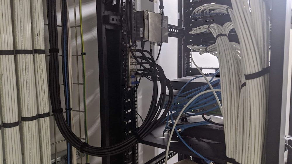 A Bunch of Wires Are Hanging From a Rack in a Server Room — Inspired Audio Visual in Coffs Harbour, NSW