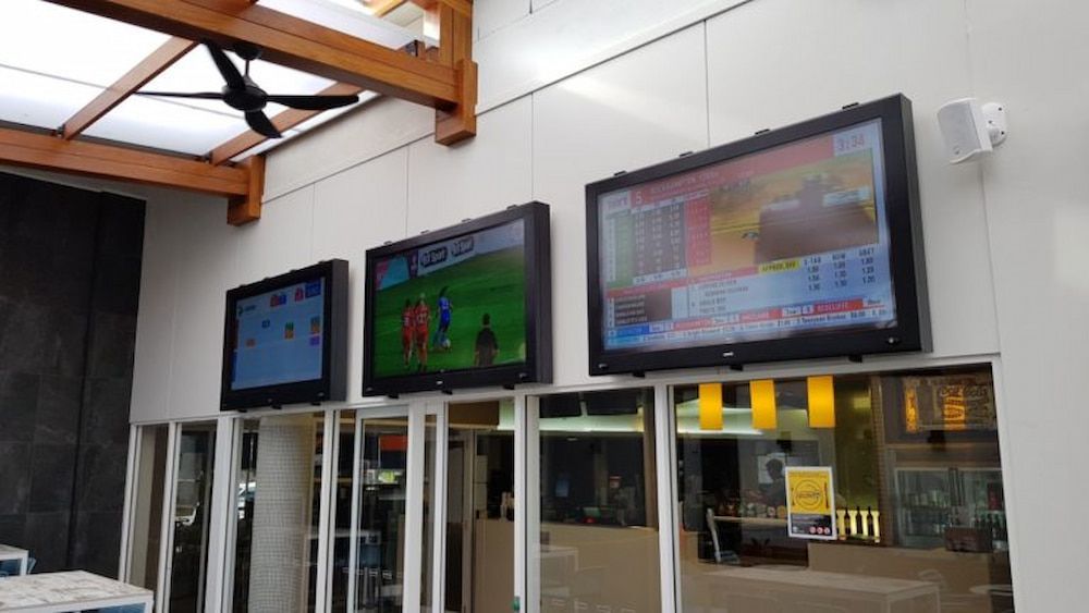 A Row of Televisions Are Hanging From the Ceiling in a Room — Inspired Audio Visual in Coffs Harbour, NSW