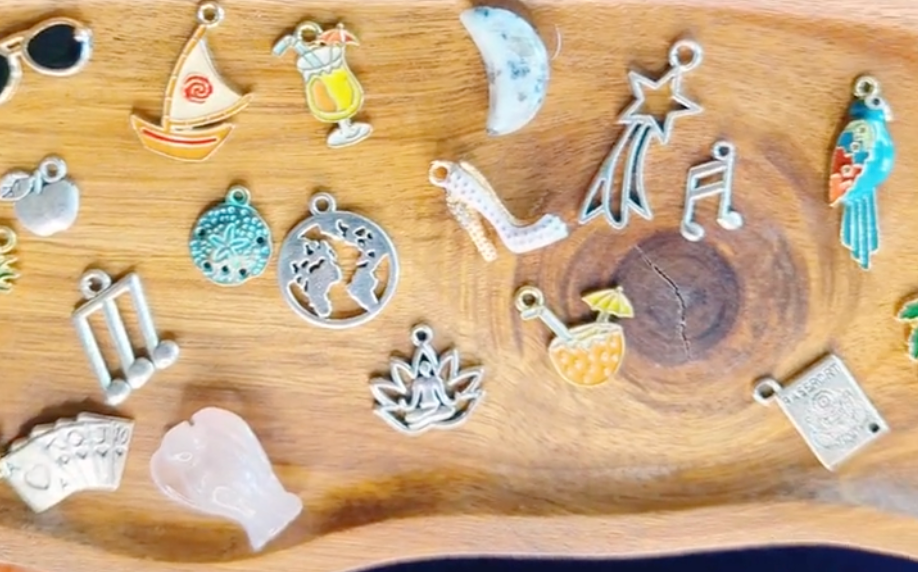 Collection of colorful charms representing tropical vacation on a wooden tray to be used for charm divination