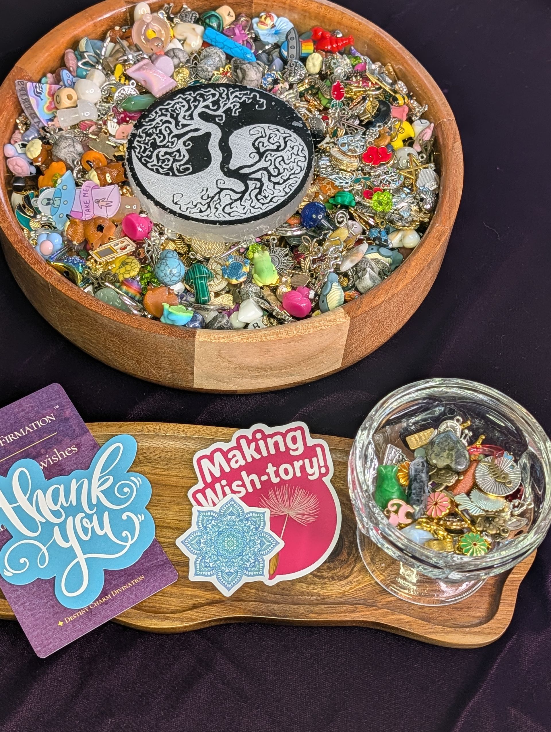 Decorative resin-filled wooden bowls and tray with colorful trinkets and “thank you” tags on a dark surface