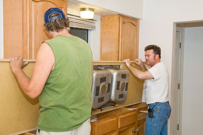 Two carpenters installing kitchen countertop