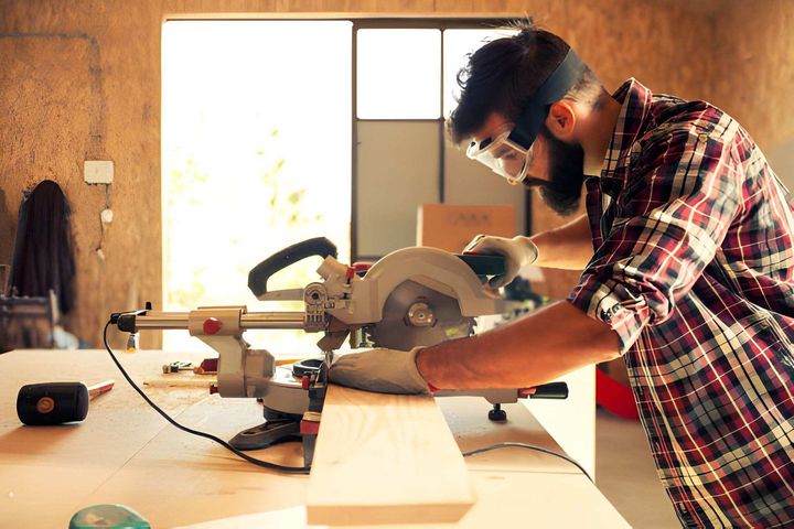 Carpenter cutting wood with circular saw