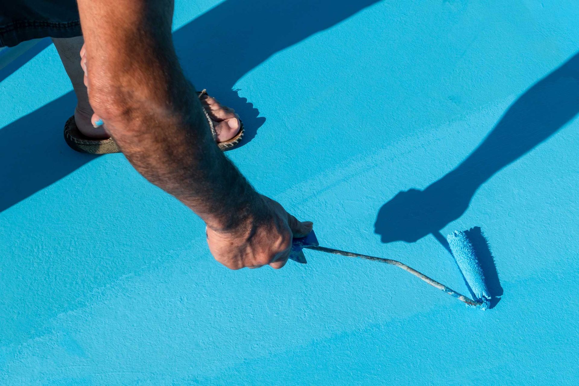 A man is painting a pool in the renovation process.