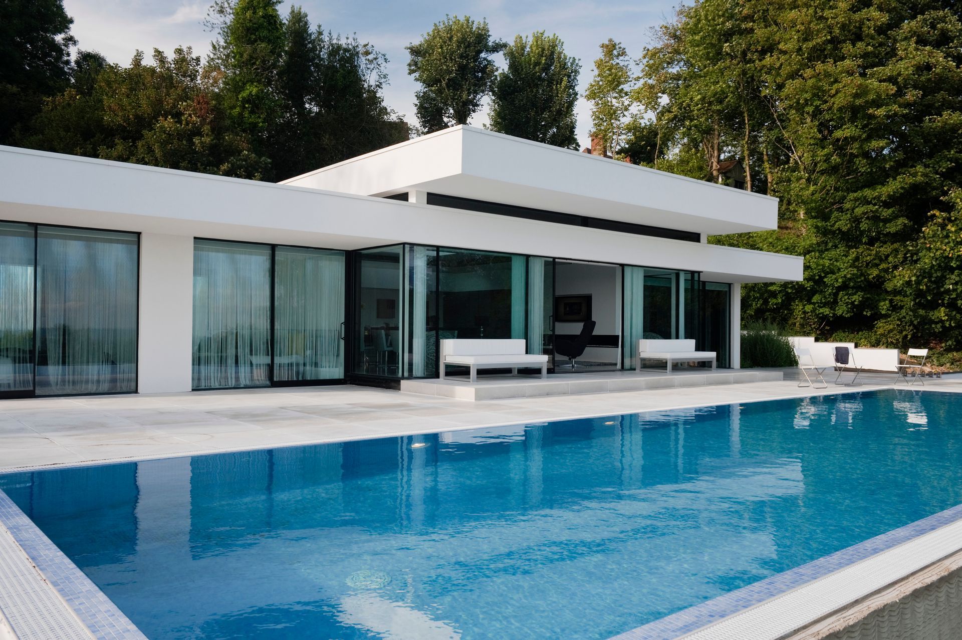 Work done by pool contractors showcasing a modern custom pool design in a stunning backyard.