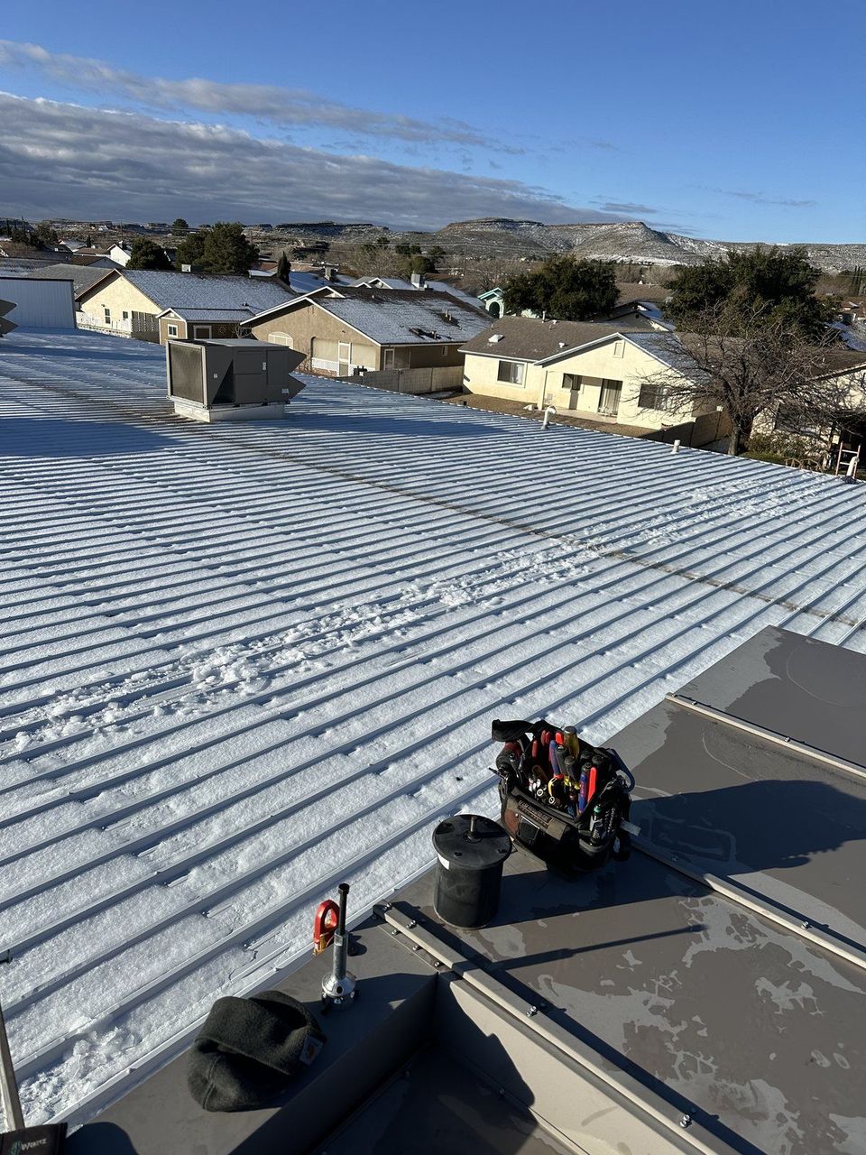 Air-Exx service tools beside a commercial rooftop HVAC unit on a snow-covered metal roof in high-country northern Arizona