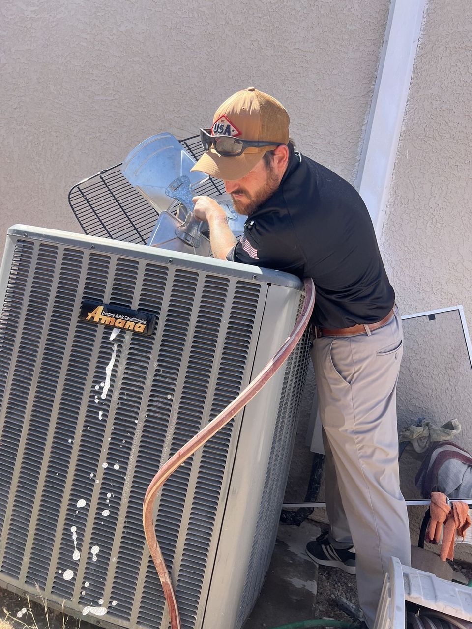 Air-Exx technician washing a condenser coil at a Kingman, Arizona home