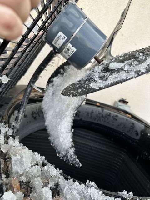 Ice on a heat pump fan blade during a defrost fault