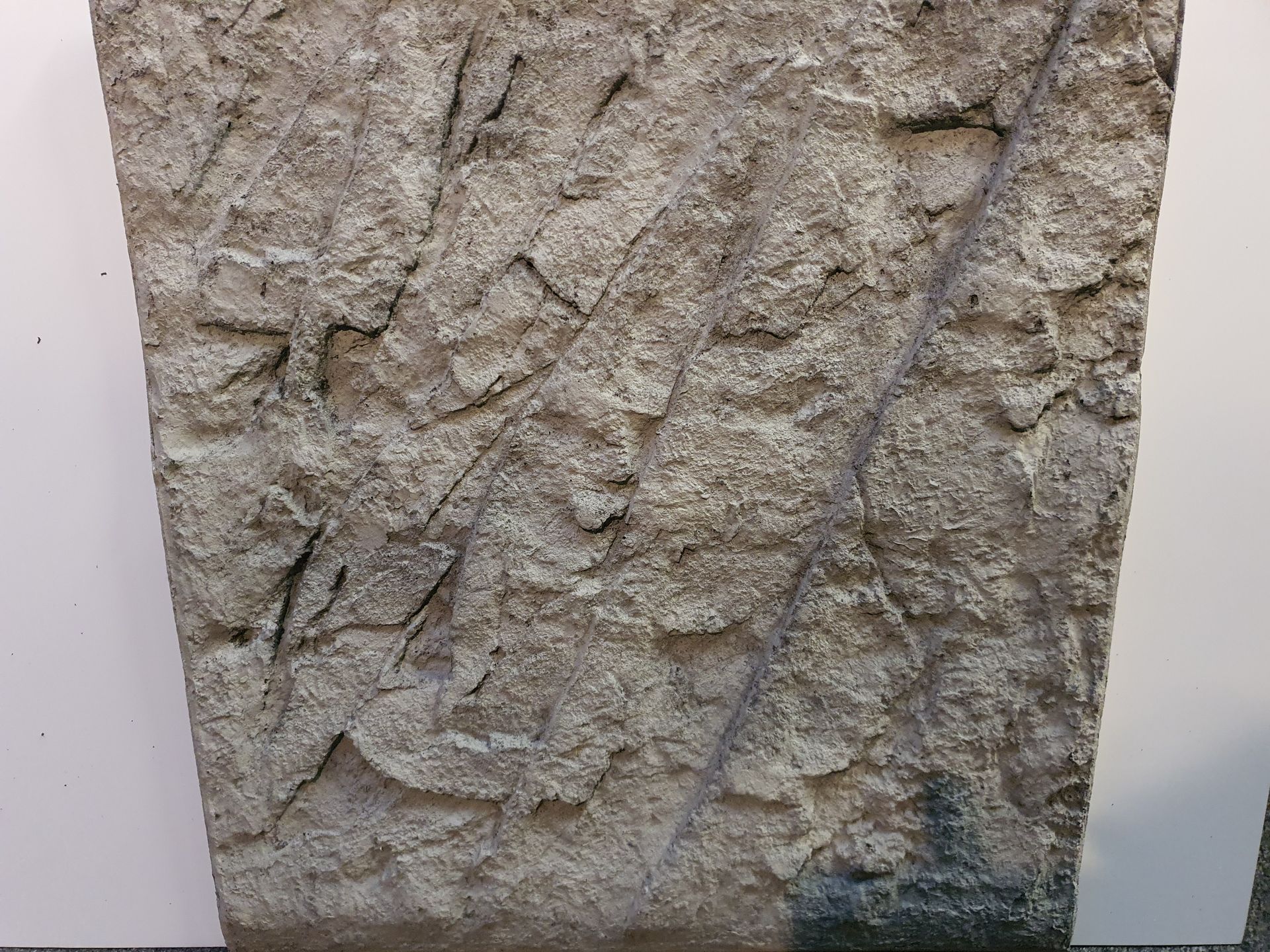 Een close-up van een stuk beton met een ruwe textuur.